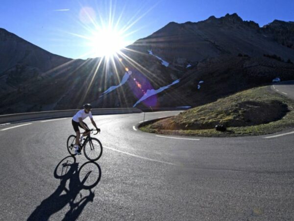 Un cycliste sur un vélo de route dans un virage du col du galibier dans les Alpes.